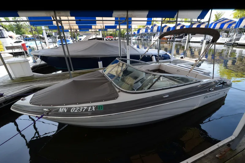 Slide: The Image of 2018 Crownline 205 SS boat docked under a canopy at a marina. - 4