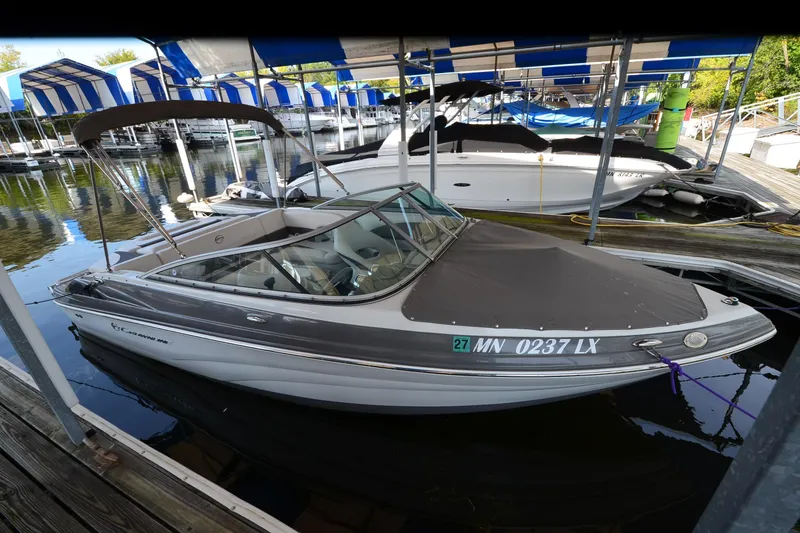 Slide: The Image of 2018 Crownline 205 SS boat docked under blue-striped canopy. - 5