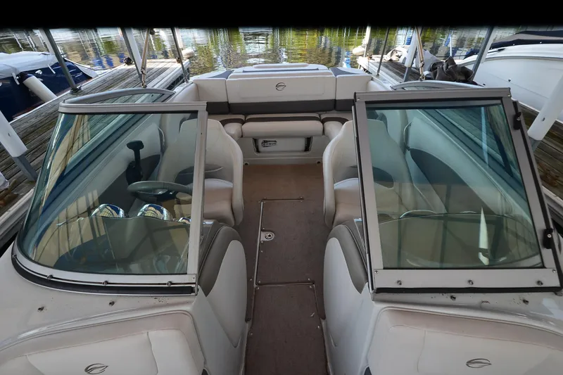 Slide: The Image of 2018 Crownline 205 SS boat interior with seating and windshield, docked by the water. - 8