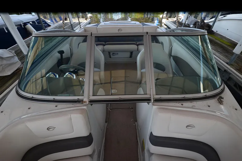 Slide: The Image of 2018 Crownline 205 SS boat interior with seating and steering wheel, docked by the water. - 9