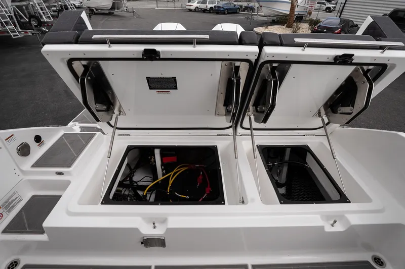 Slide: The Image of 2026 Monterey Elite 30 OB boat storage compartments open, revealing interior wiring and components. - 18