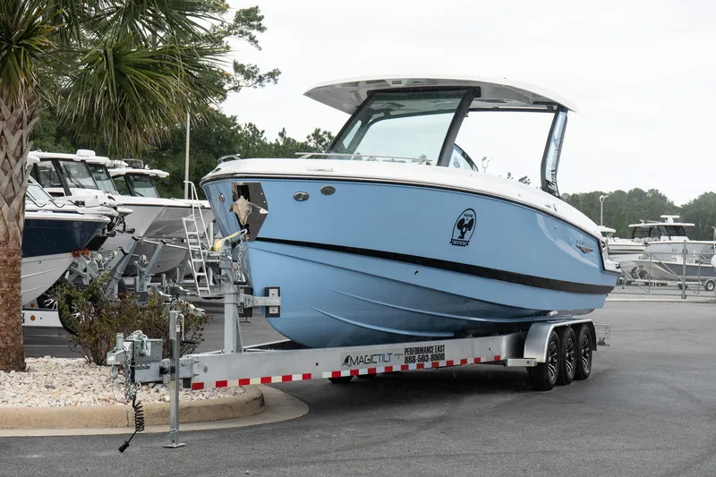 Slide: The Image of 2026 Monterey Elite 30 OB boat on trailer, parked in marina lot. - 2