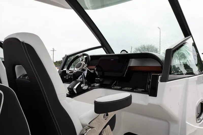 Slide: The Image of Interior of 2026 Monterey Elite 30 OB boat with modern steering and seating. - 23