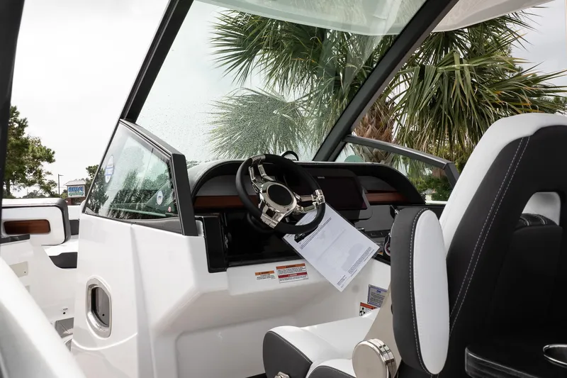 Slide: The Image of Interior view of 2026 Monterey Elite 30 OB boat with modern steering and dashboard. - 24