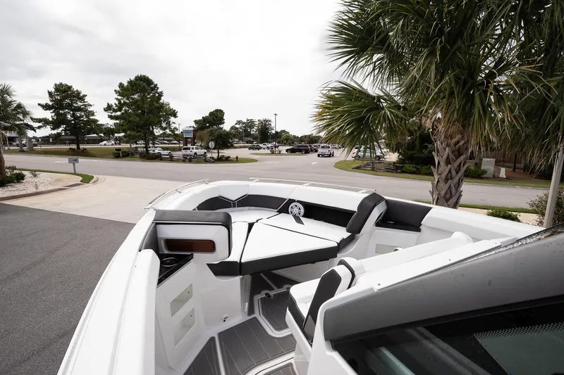 Slide: The Image of 2026 Monterey Elite 30 OB boat interior with seating, parked near palm trees. - 28