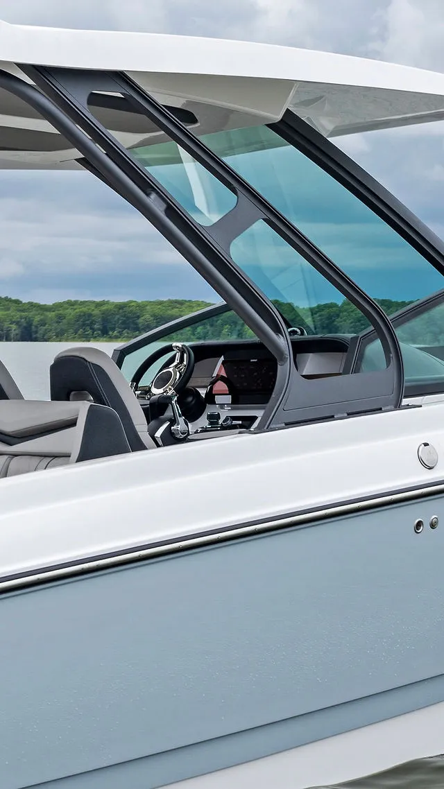 Slide: The Image of 2026 Monterey Elite 30 OB boat interior with seating, parked near palm trees. - 40