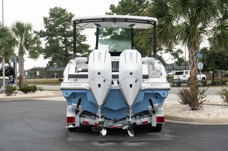 Slide: The Image of 2026 Monterey Elite 30 OB boat with dual outboard engines, parked near palm trees. - 5