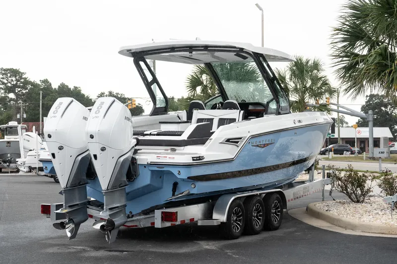 Slide: The Image of 2026 Monterey Elite 30 OB boat with dual engines on a trailer, parked outdoors. - 6