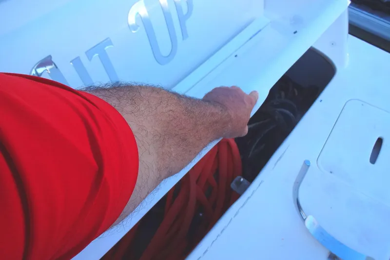 Slide: The Image of Man opening storage compartment on 2007 Meridian 459 boat deck. - 10