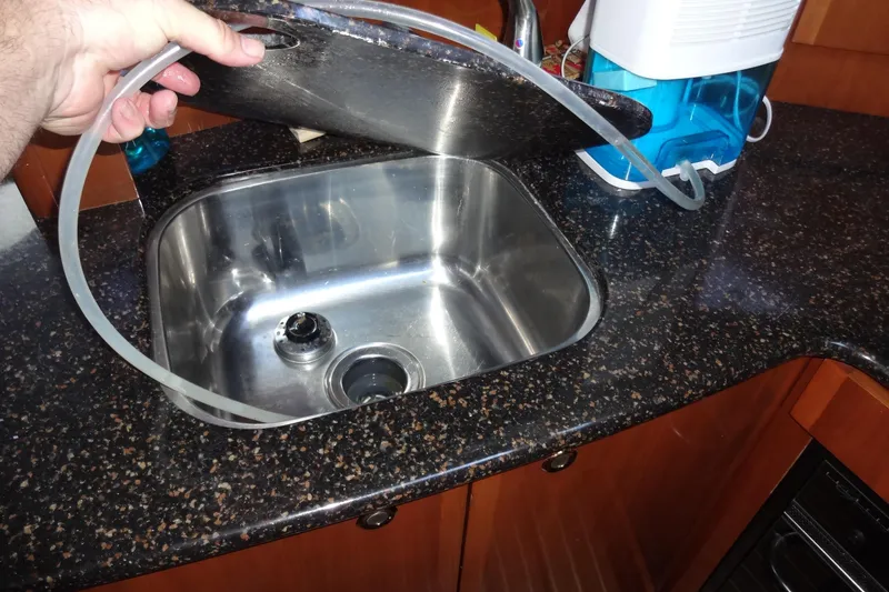 Slide: The Image of Stainless steel sink in 2007 Meridian 459 yacht kitchen with countertop and hose. - 105