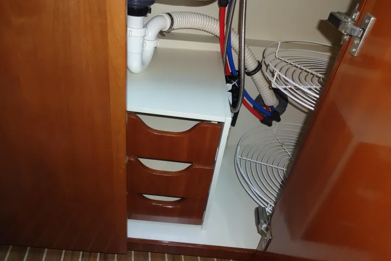 Slide: The Image of 2007 Meridian 459 yacht interior cabinet with plumbing and storage shelves. - 109