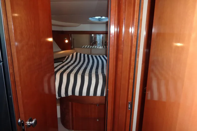 Slide: The Image of Interior cabin of 2007 Meridian 459 yacht with striped bedding and wooden finishes. - 126