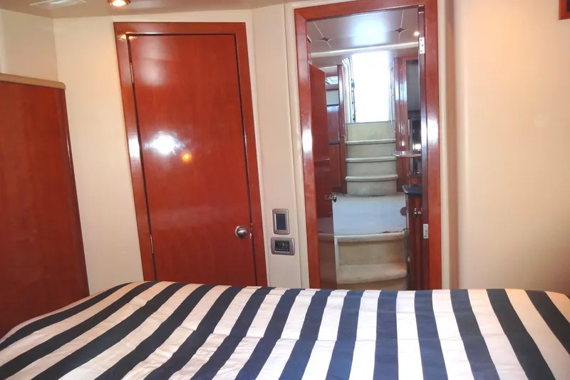 Slide: The Image of Interior of 2007 Meridian 459 yacht with striped bedding and wooden doors. - 130