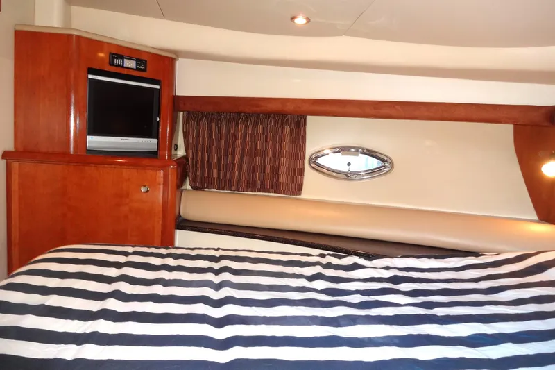 Slide: The Image of Luxurious 2007 Meridian 459 yacht interior with striped bedding and wood cabinetry. - 134