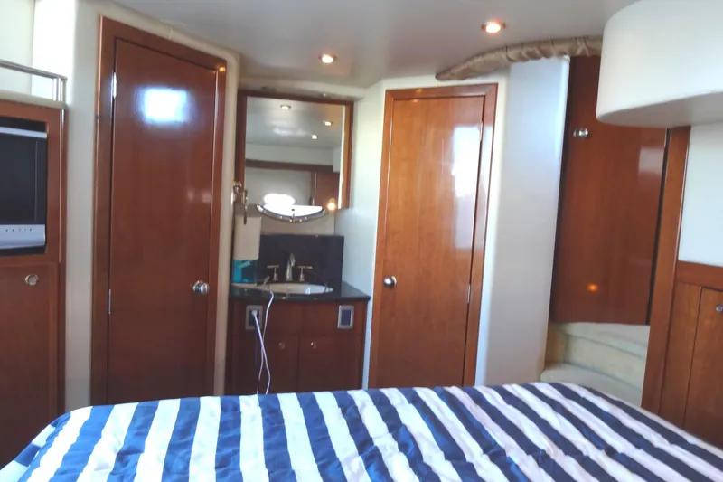 Slide: The Image of Interior of 2007 Meridian 459 yacht with wood paneling and striped bedding. - 137