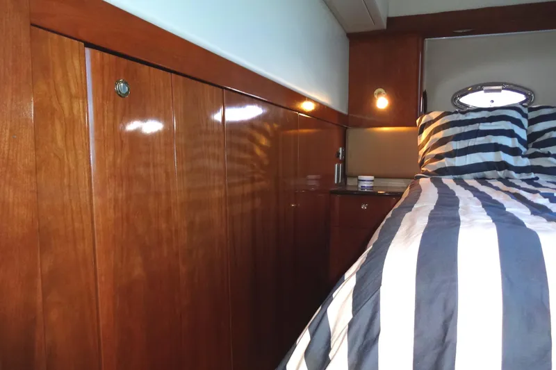 Slide: The Image of Luxurious 2007 Meridian 459 yacht cabin with wood paneling and striped bedding. - 138