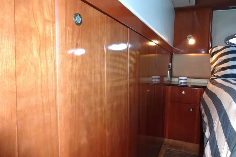 Slide: The Image of Luxurious wooden interior of a 2007 Meridian 459 yacht cabin with striped bedding. - 139