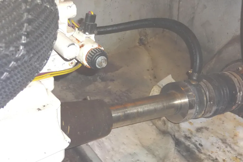 Slide: The Image of Engine component of a 2007 Meridian 459 yacht, featuring a starboard metal shaft and connected hoses. - 161