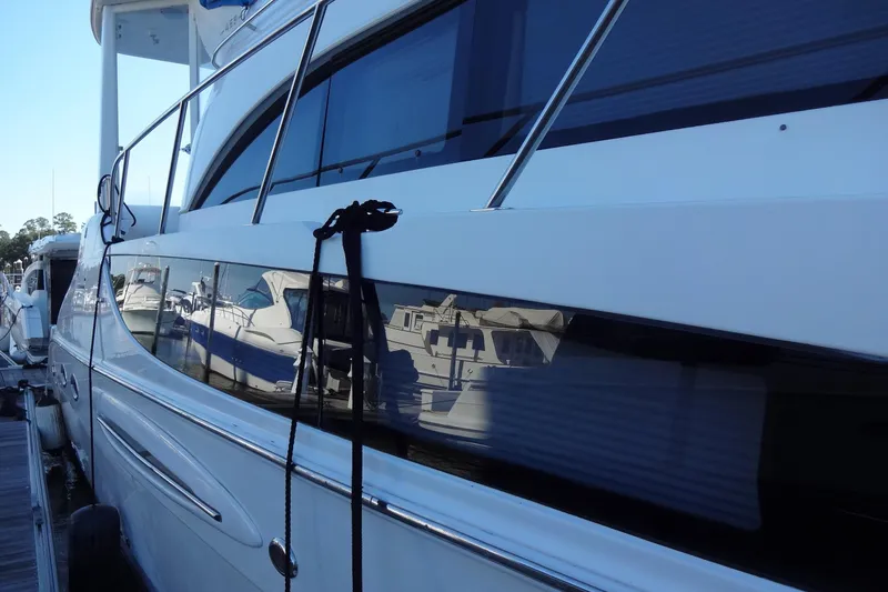 Slide: The Image of 2007 Meridian 459 yacht docked, reflecting nearby boats on its sleek exterior. - 21