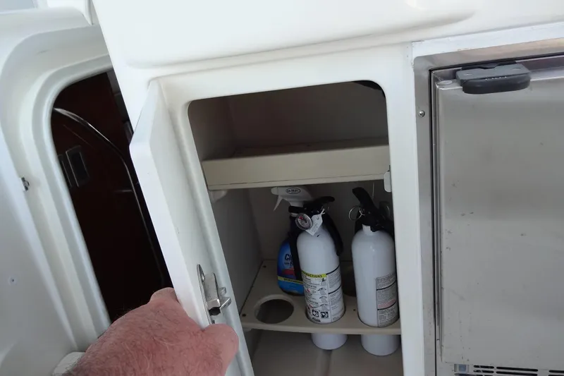 Slide: The Image of Open cabinet on 2007 Meridian 459 yacht, containing fire extinguishers and cleaning supplies. - 39