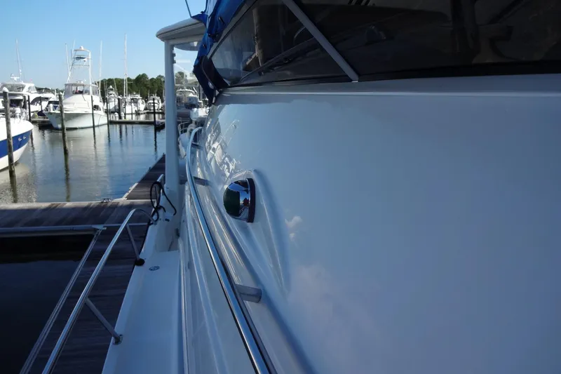 Slide: The Image of 2007 Meridian 459 yacht docked at marina, side view with clear sky reflection. - 47