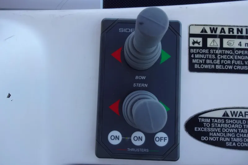 Slide: The Image of Control panel of a 2007 Meridian 459 boat with thruster controls and warning labels. - 69