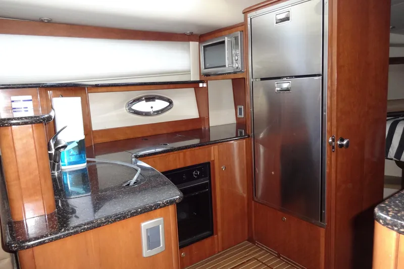 Slide: The Image of Luxurious 2007 Meridian 459 yacht kitchen with wood cabinetry and stainless steel appliances. - 96