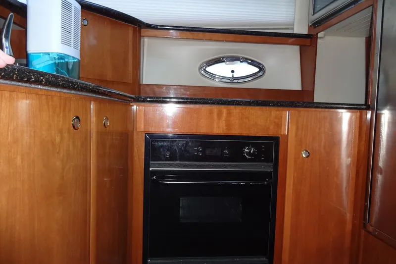 Slide: The Image of 2007 Meridian 459 yacht kitchen with wood cabinetry and built-in oven. - 98