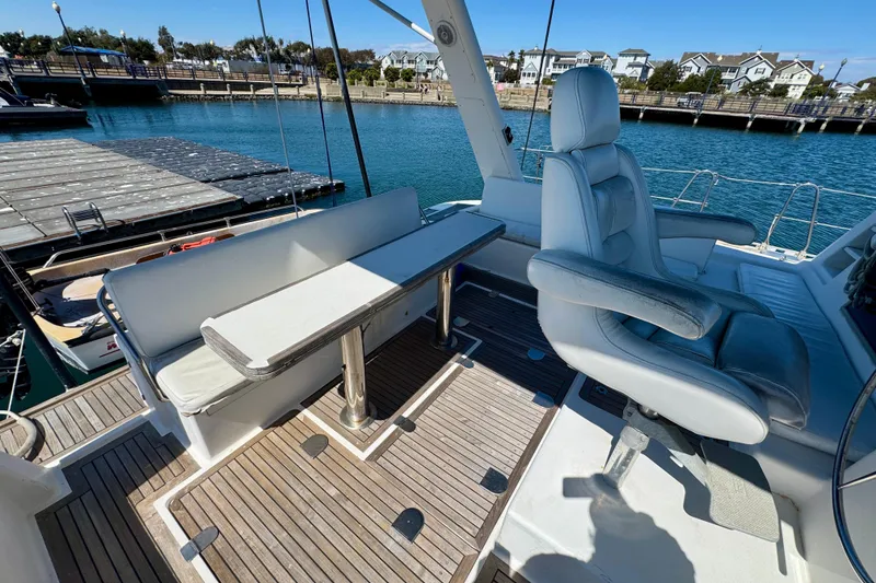 Slide: The Image of Luxury seating area on a 1992 Wauquiez Kronos yacht, docked at a marina. - 10