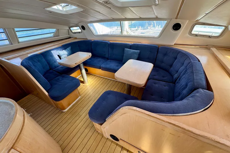 Slide: The Image of Luxurious 1992 Wauquiez Kronos yacht interior with blue cushioned seating and wooden flooring. - 12