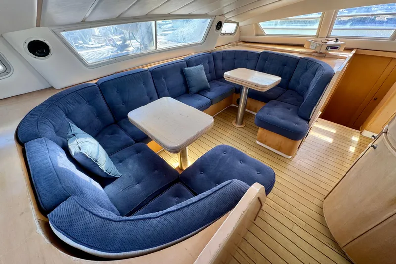 Slide: The Image of Luxurious 1992 Wauquiez Kronos yacht interior with blue seating and wooden flooring. - 15