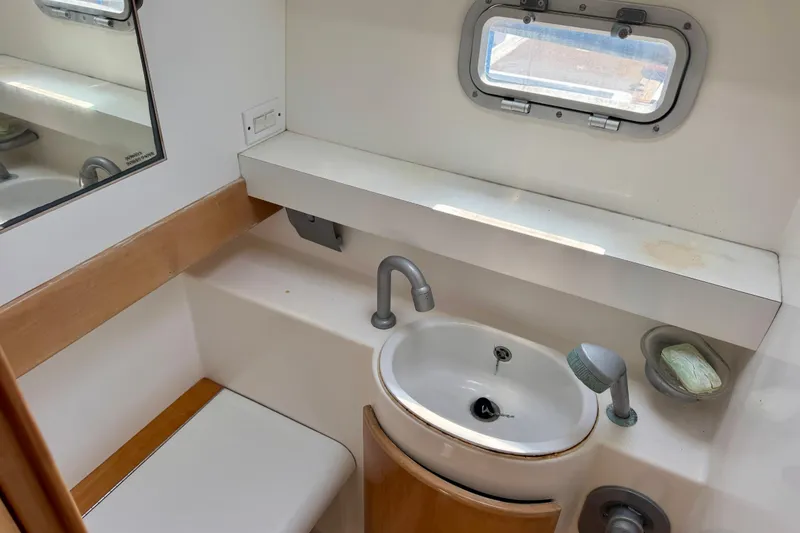Slide: The Image of Bathroom interior of 1992 Wauquiez Kronos yacht with sink, mirror, and porthole window. - 22
