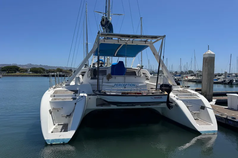 Slide: The Image of 1992 Wauquiez Kronos catamaran docked in a marina under clear blue skies. - 5