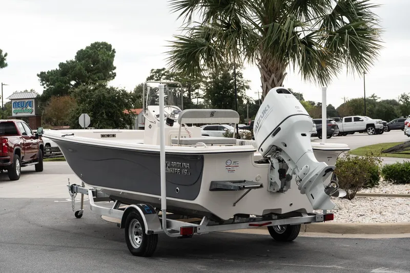 Slide: The Image of 2025 Carolina Skiff 19 LS boat on trailer, parked near palm tree. - 4