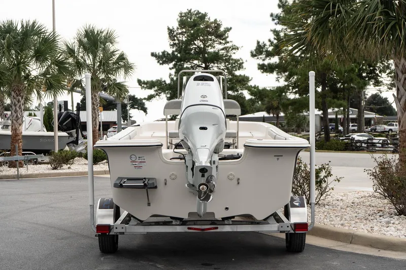 Slide: The Image of 2025 Carolina Skiff 19 LS boat on trailer, parked outdoors with palm trees. - 5