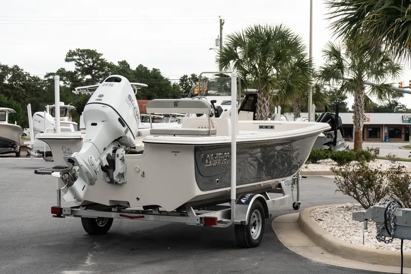 Slide: The Image of 2025 Carolina Skiff 19 LS boat on trailer, parked outdoors near palm trees. - 6