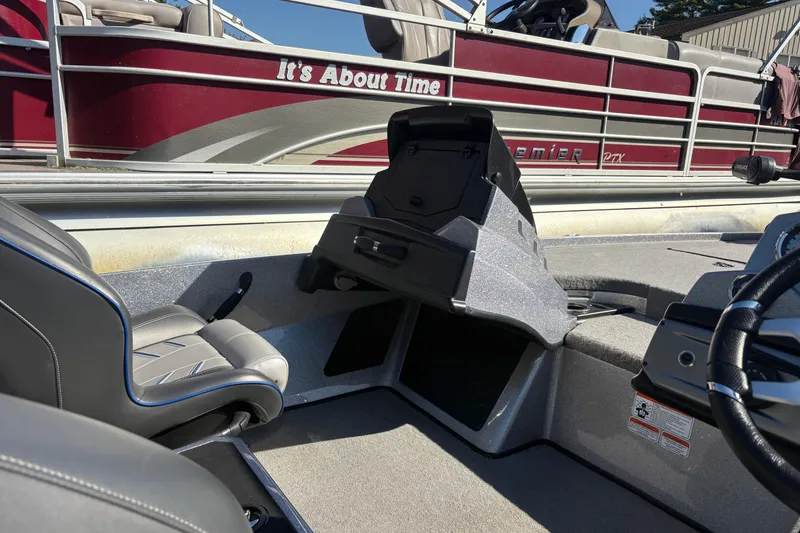 Slide: The Image of 2024 Nitro Z19 Pro boat interior with seating and dashboard, docked near a red pontoon. - 19