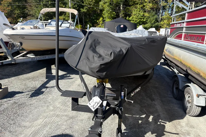 Slide: The Image of 2024 Nitro Z19 Pro boat covered, parked among other boats in a sunny outdoor setting. - 5