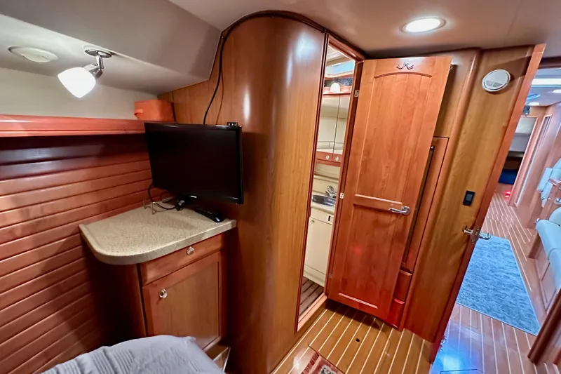 Slide: The Image of Interior of 2008 Hunter 49 yacht with wood paneling, TV, and compact bathroom. - 104