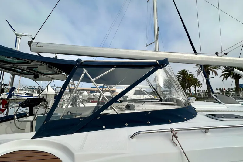 Slide: The Image of 2008 Hunter 49 sailboat with blue canopy docked at marina. - 12