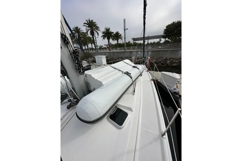 Slide: The Image of 2008 Hunter 49 sailboat deck with inflatable dinghy, docked near palm trees. - 15