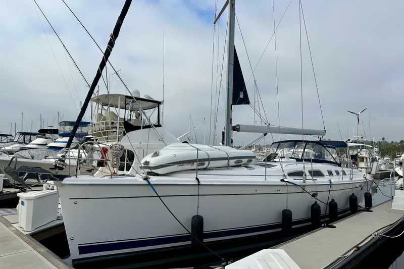 Slide: The Image of 2008 Hunter 49 sailboat docked at marina, surrounded by other boats. - 2