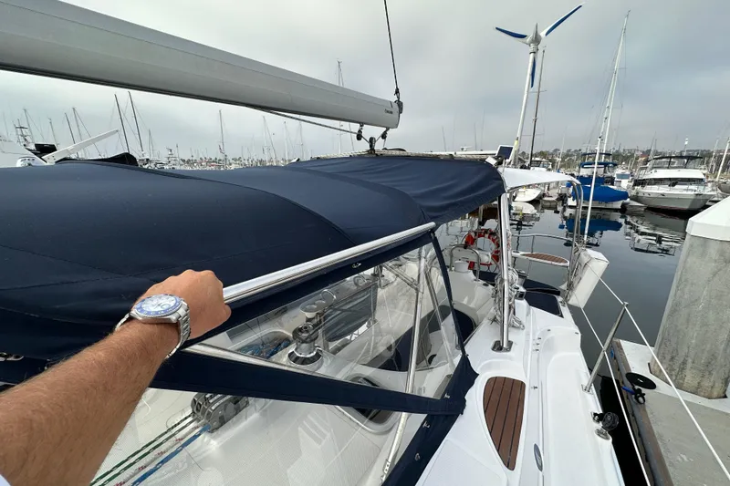 Slide: The Image of Sailboat Hunter 49, 2008 model, docked in marina with blue canopy and wind turbine. - 21