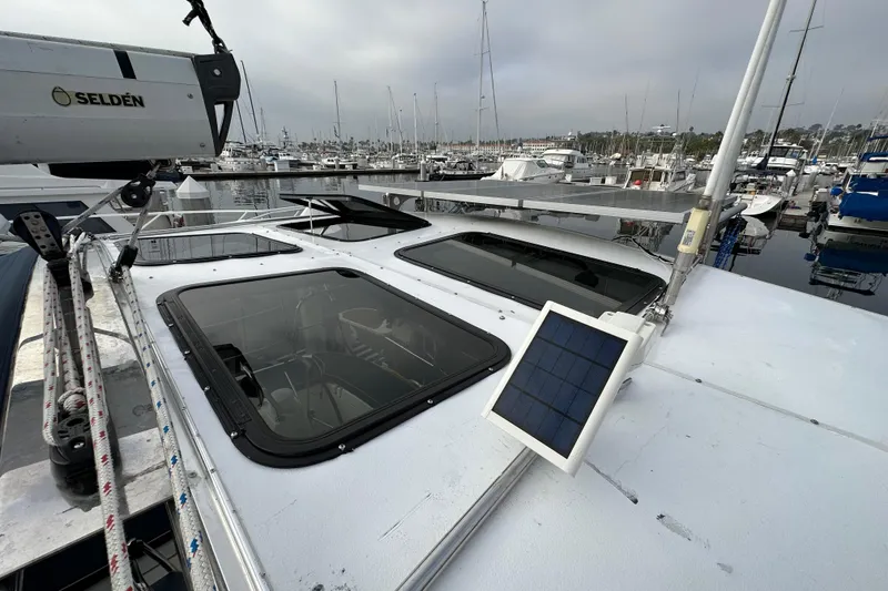 Slide: The Image of 2008 Hunter 49 sailboat with solar panel, docked in marina, overcast sky. - 24