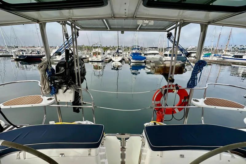 Slide: The Image of 2008 Hunter 49 yacht docked in marina, surrounded by boats and calm water. - 28