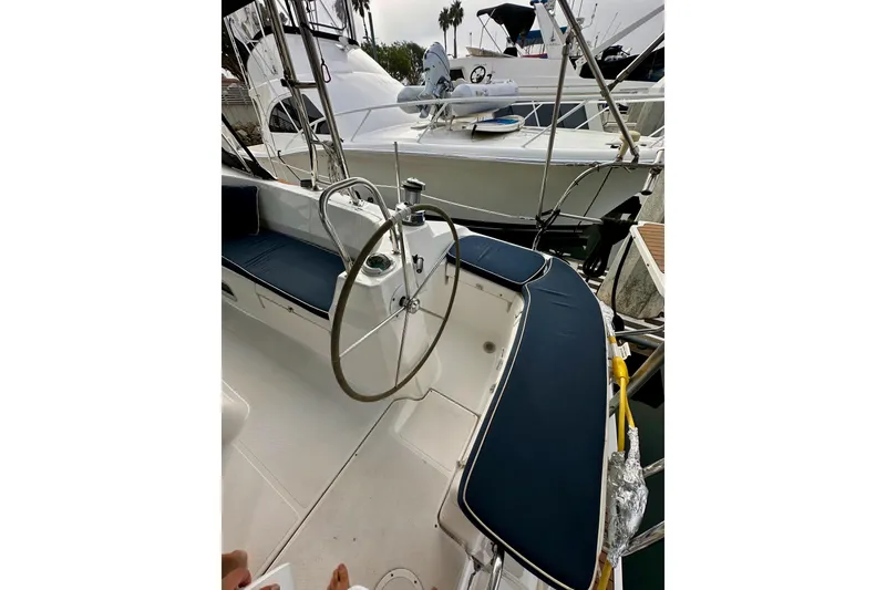 Slide: The Image of 2008 Hunter 49 sailboat cockpit with steering wheel and blue seating at marina. - 36