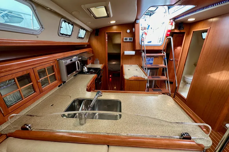 Slide: The Image of Luxurious 2008 Hunter 49 yacht interior with modern kitchen and wooden cabinetry. - 52