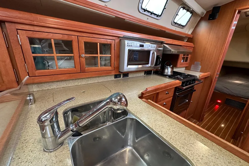 Slide: The Image of Luxurious 2008 Hunter 49 yacht kitchen with modern appliances and elegant wood cabinetry. - 53