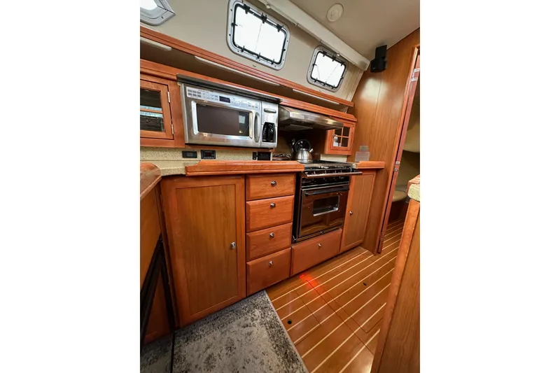 Slide: The Image of 2008 Hunter 49 yacht kitchen with wood cabinetry, stainless appliances, and sleek design. - 54