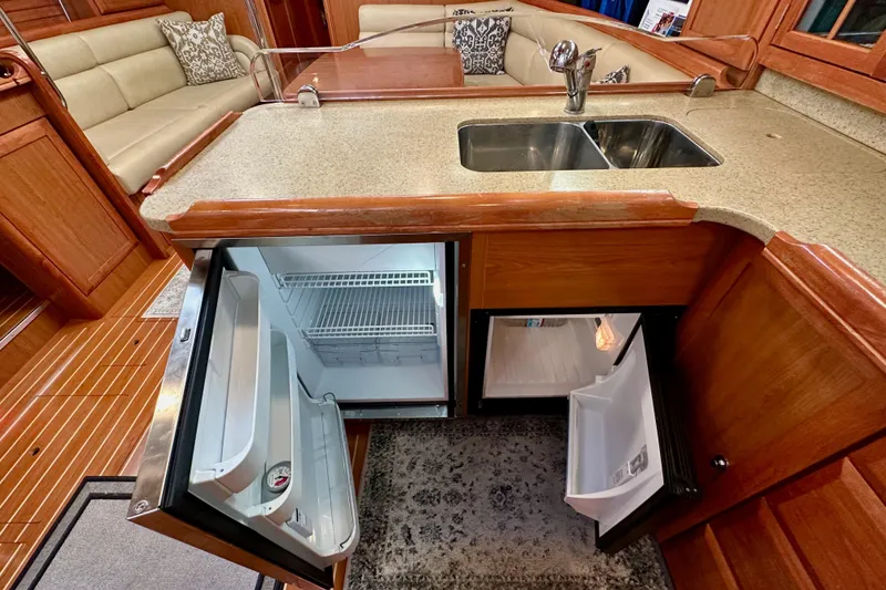 Slide: The Image of Luxurious 2008 Hunter 49 yacht interior with open fridge, sink, and seating area. - 70